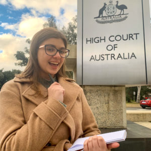 Smiling Beth Muir standing in front of the High Court of Australia