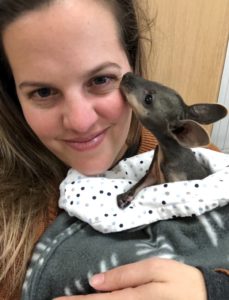 Amy Edwards holding a small joey
